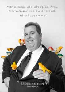 Mann im Anzug mit bunten Vögeln.