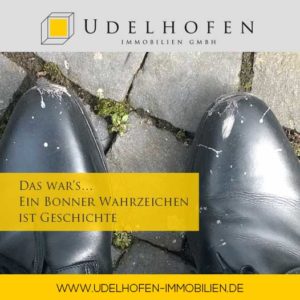 Schuhe mit Vogelkot auf Kopfsteinpflaster