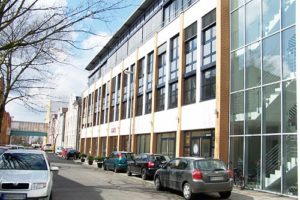 Moderne Bürogebäude und parkende Autos in der Straße.